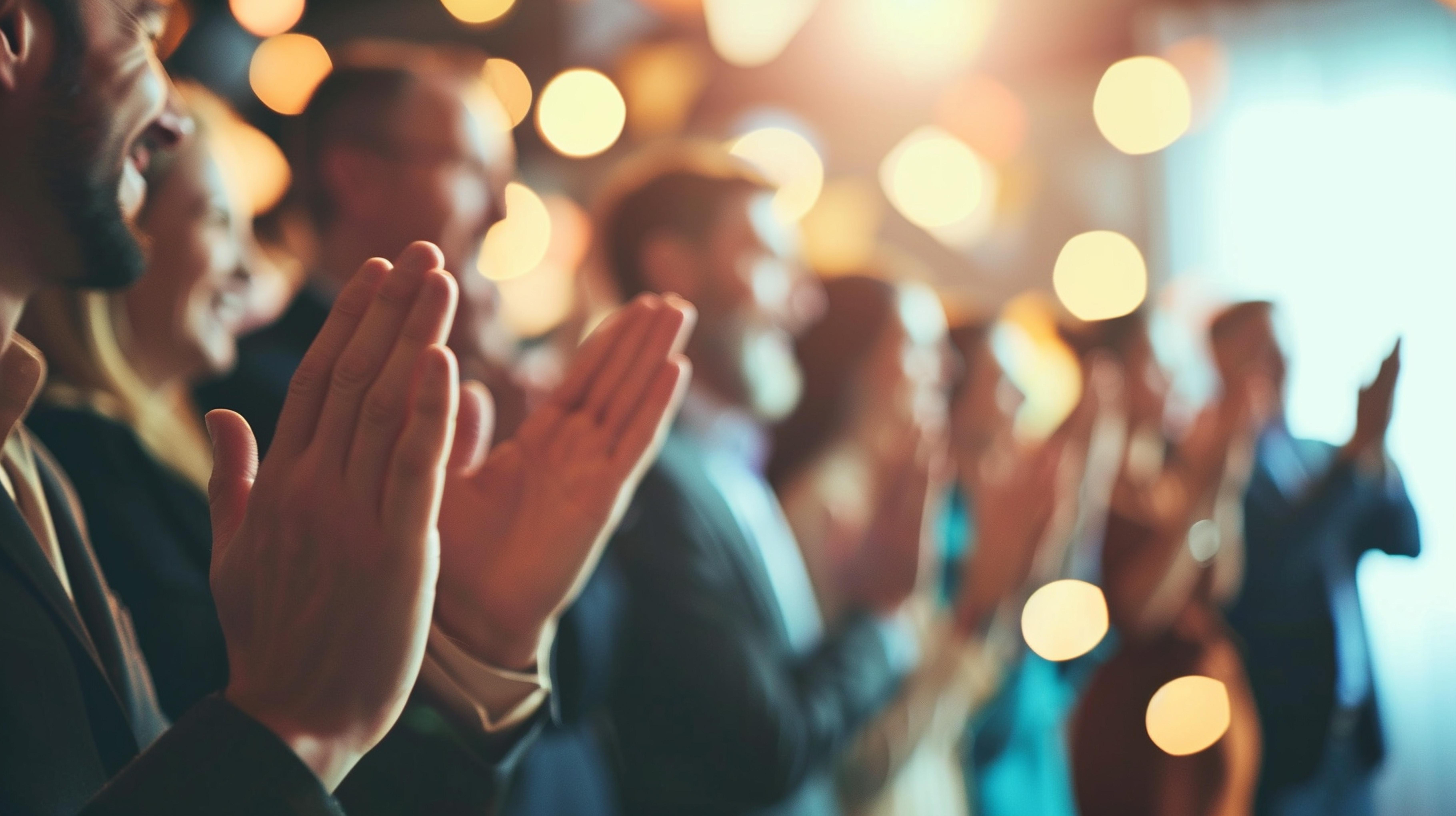 Colleagues giving a standing ovation to an awarded team member,