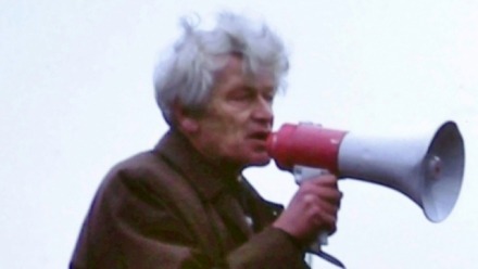 old man in political rally with microphone